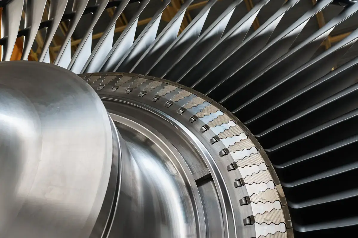 Shiny rotor of powerful steam turbine in light workshop